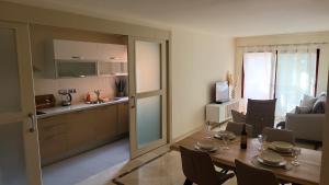 a kitchen and a dining room with a table and chairs at Geweldig Appartement in Los Alcázares direct aan de Boulevard in Los Alcázares