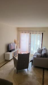 a living room with a couch and a tv at Geweldig Appartement in Los Alcázares direct aan de Boulevard in Los Alcázares