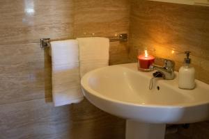 Łazienka z umywalką ze świecą w obiekcie PUESTA DE SOL RENTALS 2AJ w mieście Playa de San Juan +30 zdjęć