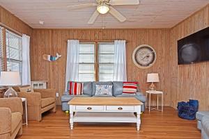 a living room with a couch and a ceiling fan at Chelsea House in Oak Island