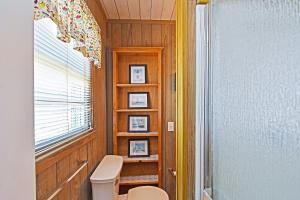 a bathroom with a toilet and a window at Chelsea House in Oak Island +20 photos
