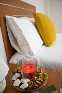 świeca na talerzu na stole obok łóżka w obiekcie PUESTA DE SOL RENTALS 2AJ w mieście Playa de San Juan