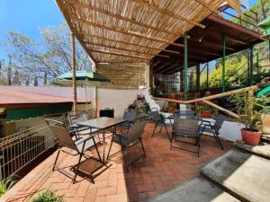 a patio with a table and chairs and an umbrella at Hotel Paraje Casa Blanca in San Agustín Etla