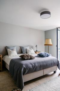 una camera bianca con un grande letto con due cuscini di NeNe a Dilbeek