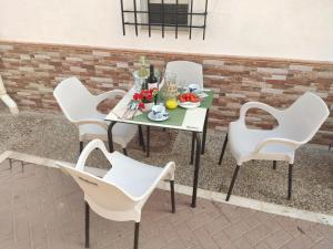 a table with white chairs and a plate of fruit at Casita La Playa in Málaga +48 photos