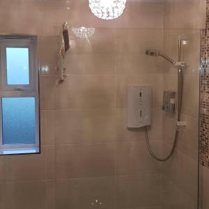 a bathroom with a shower and a window at Causeway Coast Ground Floor Apartment Sleeps 5 in Armoy