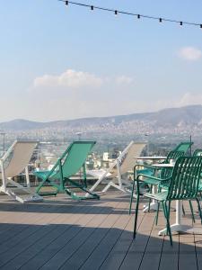 eine Gruppe von Stühlen und Tischen auf einem Dach in der Unterkunft Evripides Hotel in Athen