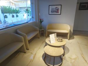 een wachtkamer met banken, een tafel en een raam bij Sun Hotel in Polykhrono