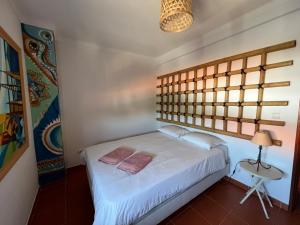 a bedroom with a white bed and a lamp at Casa das Dunas in Almograve