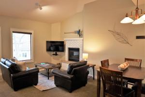 Bay Colony 773 - Upper في Nisswa: غرفة معيشة بها موقد وطاولة وكراسي
