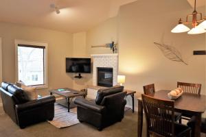 a living room with a fireplace and a table and chairs at Lakefront Gull Lake 2BR Condo Boat Rentals Available Bay Colony 773 in Nisswa