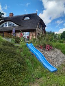 a blue slide in the grass in front of a house at Ferienwohnung Böttcher in Putbus