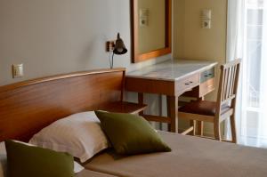 a bedroom with a bed with a desk and a mirror at Evripides Hotel in Athens