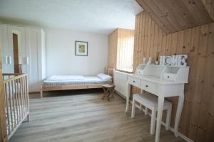 a room with a desk and a bed in it at Ferienwohnung Vogelschar Urlaub auf dem Lebenshof in Kiebitz