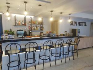 a bar with chairs and a counter with sun hotel at Sun Hotel in Polykhrono
