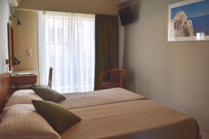 a hotel room with two beds and a window at Evripides Hotel in Athens