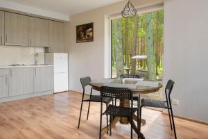 a kitchen and dining room with a table and chairs at Vezezeris in Gaugariai