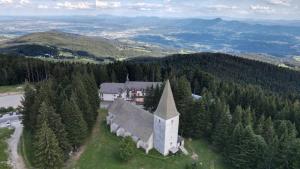 uma vista aérea de uma igreja no meio das árvores em Brunarica 6A - Smučišče Trije Kralji em Oplotnica