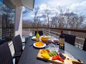 een tafel met twee glazen wijn en een dienblad met eten bij Baberu - Vacation STAY 13021 in Nasushiobara