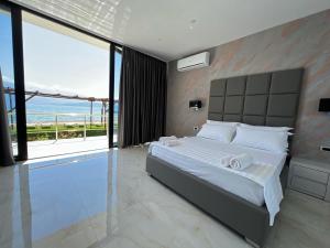 um quarto com uma cama e vista para o oceano em Hotel Victoria em Pogradec
