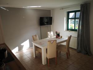 a dining room with a white table and chairs at Ferienwohnung Gerda in Groß Stresow