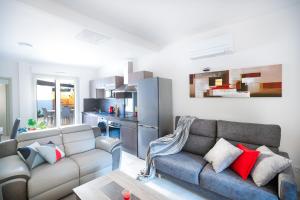 ein Wohnzimmer mit einem Sofa und einer Küche in der Unterkunft Superbe appartement à 2 pas des Halles, Climatisé, terrasse, garage in Narbonne