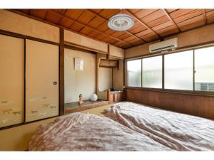 ein Schlafzimmer mit einem großen Bett und einem Fenster in der Unterkunft Katsura Club - Vacation STAY 13032 in Kyoto