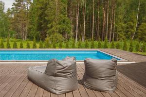 a couple of pillows sitting on a deck next to a pool at Vezezeris in Gaugariai