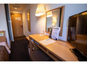 um quarto de hotel com uma secretária e uma televisão em AZ INN HANDA INTER - Vacation STAY 69359v em Handa