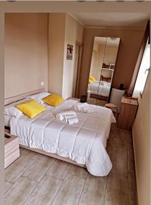 um quarto com uma grande cama branca com almofadas amarelas em Martina Paradise Affitta Camere em Nicolosi