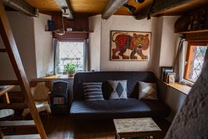 una sala de estar con un sofá azul en una habitación en Marko's eco cabin, en Bled
