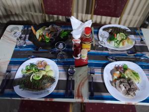 Sekenani的住宿－Tayari Luxury Tented Camp - Mara，一张桌子上放着三盘食物