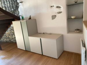 a white cabinet in a room with a staircase at La Maison du Cre in Valtournenche