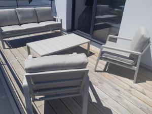 un par de sillas y un banco en una cubierta en Maison à 200m des plages avec jacuzzi, en Trégunc