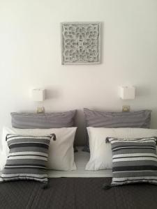 a white bed with black and white pillows at Rodia Studios & Apartments in Parikia