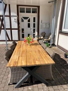 a wooden table with flowers on a patio at Deutsches Haus in Willingen