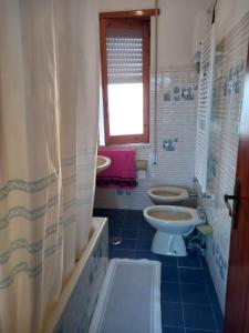 łazienka z 2 toaletami, umywalką i oknem w obiekcie G&M Holiday Home 2 w mieście Minturno