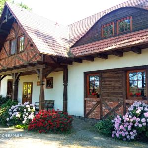 dom z kwiatami przed nim w obiekcie Pensjonat u Garncarza w mieście Polnica