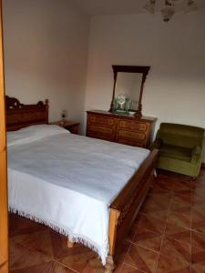 a bedroom with a bed and a mirror and a chair at G&M Holiday Home 2 in Minturno