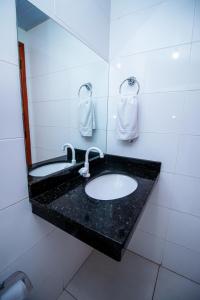 a bathroom with a sink and a mirror at Hotel Flor de Lotus in Santa Isabel do Pará