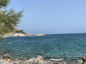 a group of people on a beach near the water at Residence _Capo Gallo in Palermo