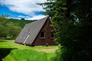 a small house with a roof on a field at Bright Star Lodge in Spean Bridge