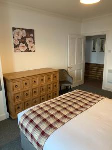 a bedroom with a bed and a dresser at Traditional Caithness Stone house in Wick