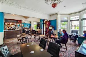 a restaurant with people sitting in chairs and tables at Guest House @ The Bear in Weston-super-Mare