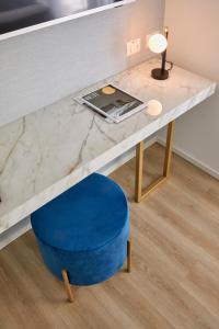 a table with a blue ottoman and a desk with a laptop at Riva Palace Hotel in Grado