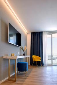 sala de estar con escritorio y silla amarilla en Riva Palace Hotel en Grado