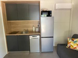 a small kitchen with a refrigerator and a sink at Mobile home Privlaka in Privlaka