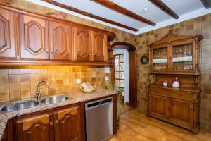 a kitchen with wooden cabinets and a sink at Casa Seara Piscina, Wifi y 400 metro de la playa, in Arrecife
