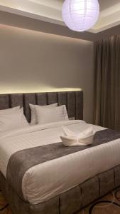فندق جولدن الأندلس في أبها: غرفة نوم بسرير كبير مع وسادتين بيضاء