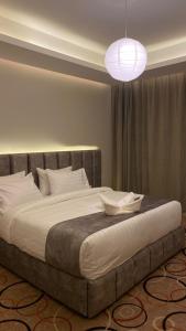 a bedroom with a large bed with a light fixture at Golden Andalus Hotel in Abha